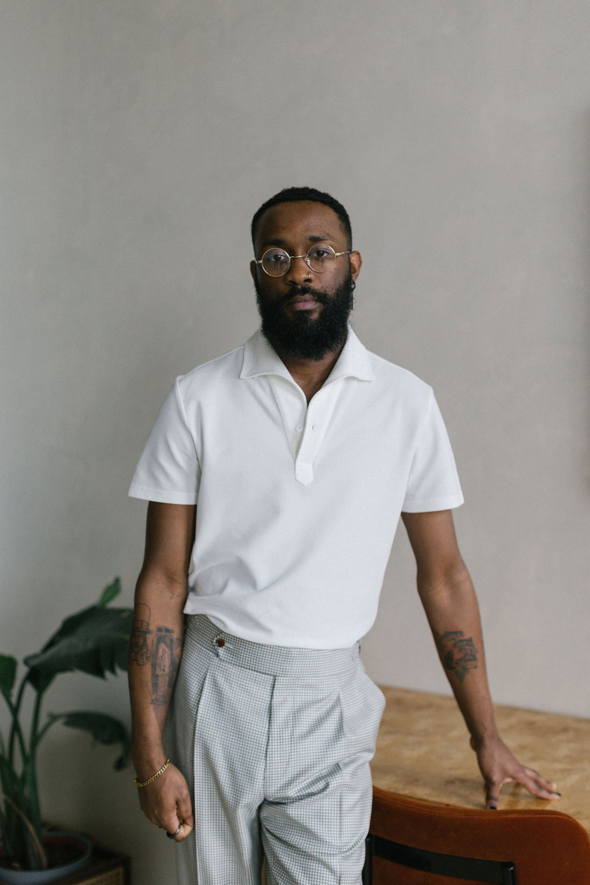 White Polo shirt with one piece collar and short sleeves tucked in with a check pant