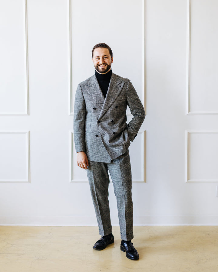 Double breasted suit in beige and a white polo shirt with black and white penny loafers
